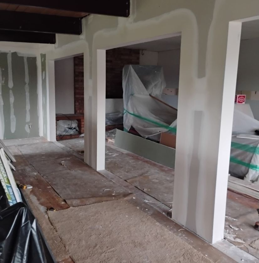 Interior renovation with exposed framing and unfinished flooring