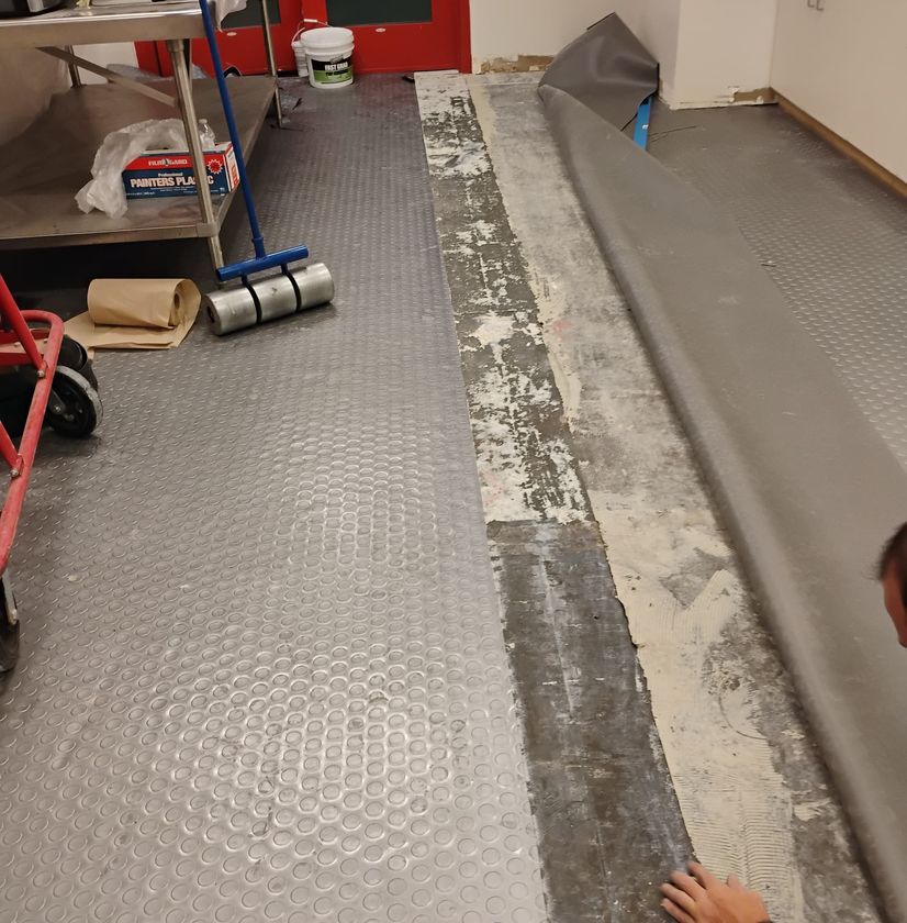 Basement flooring installation along wall and stairs