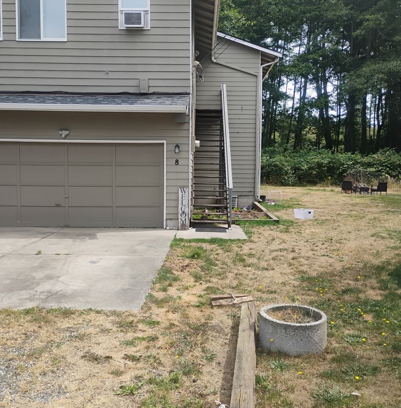 Exterior house renovation with new concrete walkway and landscaping work